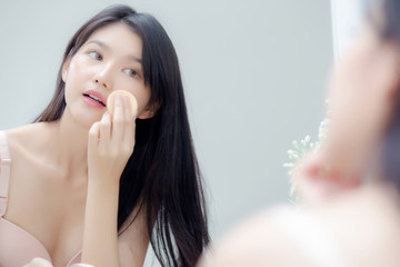 Wall Mural - Closeup hand of young asian woman holding product cosmetic applying cream in jar, beautiful girl hand touch lotion for rejuvenation, beauty perfect, treatment and skin care and health concept.