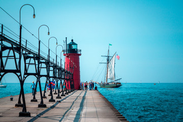 Wall Mural - Tall ship sailing past a lighthouse on a summer day in South Haven