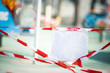 © Дарья Шуйскова - protective guard tape on the playground, white plate blank, place for text, mock-up. Closing all areas outside the during an epidemic and pandemic coronavirus, covid-19. Copy Space