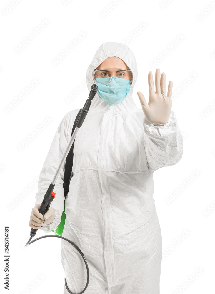 Worker in biohazard suit and with disinfectant showing stop gesture on white background