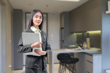 Sticker - Asian businesswoman standing while carrying the laptop working from home