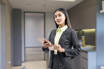 Sticker - Asian businesswoman standing while using a tablet working from home