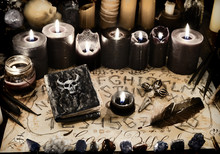 Evil Book With Black Magic Spells, Candles And Ouija Board On Witch Table.