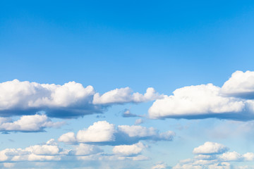 Wall Mural - many low small cumulus clouds in blue sky on March day