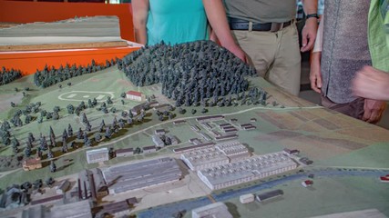 group of people view a scale model of the town. Guide explain the details