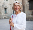 © JackF - Elegant mature woman is posing in time walking on the street of old city
