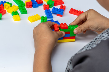 Thailand, bangkok. April 28, 2020. Children hands play with colorful lego blocks on white background.