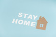 © zzzdim - Stay home message laid on a blue surface along with house shape
