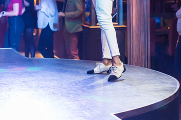 Dancing shoes feet and legs of male ballroom and latin salsa dancer dance teacher on the stage. Social dance, bachata solo and kizomba concept