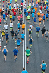 Runners on the street. Athletes in motion. Urban competition. Crowd