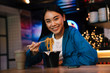 Photo of joyful nice asian woman eating chinese noodles in cafe