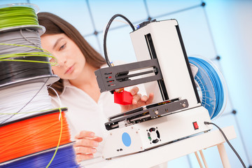 Sticker - Young female designer working on a prototype device on a 3D printer