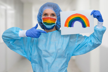 Portrait of a doctor in a mask, on which a rainbow is drawn as a sign of hope of victory over a coronovirus infection