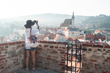 Photographer tourist taking pictures of European city Cesky Krumlov Czech Republic city on a sunny day