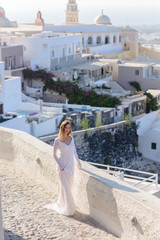 Sticker - Beautiful bride In a white dress posing against the backdrop of the city of Thira, Santorini.