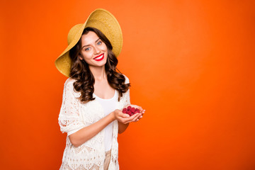 Wall Mural - Photo of beautiful lady enjoy vacation time holding fresh raspberry wearing panama light beach stylish cardigan white underwear isolated vivid orange background