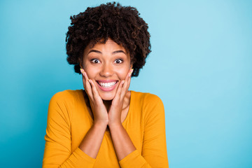 Wall Mural - Omg i cant believe. Close up photo enthusiastic cheerful afro american girl wait long expected wish present touch hands face wear style stylish trendy sweater isolated blue color background