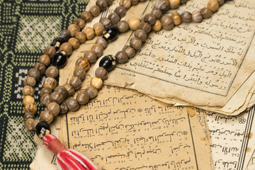 Poster - Muslim prayer beads with ancient pages from the Koran. Islamic and Muslim concepts. Ancient old sheets of paper from the Arabic book