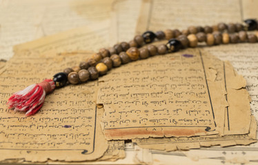 Sticker - Muslim prayer beads with ancient pages from the Koran. Islamic and Muslim concepts. Ancient old sheets of paper from the Arabic book