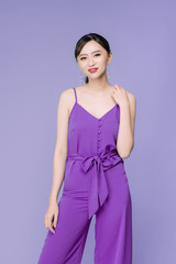 Wall Mural - Portrait of beautiful young Asian woman over violet background.