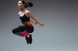 © LIGHTFIELD STUDIOS - sportive woman in sportswear jumping on grey