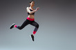 © LIGHTFIELD STUDIOS - pretty woman in sportswear jumping on grey