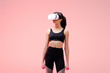 © LIGHTFIELD STUDIOS - african american sportswoman in virtual reality headset holding dumbbells on pink