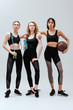 © LIGHTFIELD STUDIOS - sportive and multicultural girls standing with sport equipment on white