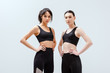 © LIGHTFIELD STUDIOS - attractive and multicultural women in sportswear standing with hands on hips isolated on white
