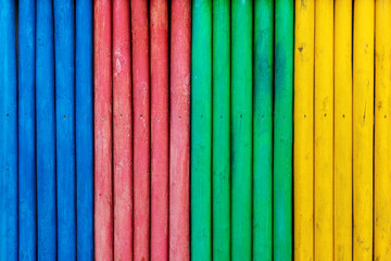 Colorful wooden fence painted in blue, red, green and yellow colors.