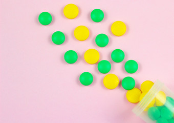 Wall Mural - Colorful pills and tablets on a pink background.