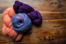 Three Skeins Of Richly Colored Yarns Gathered On An Old Wooden Background, Old World Handcraft Knitting And Crochet, Copy Space, Horizontal Aspect