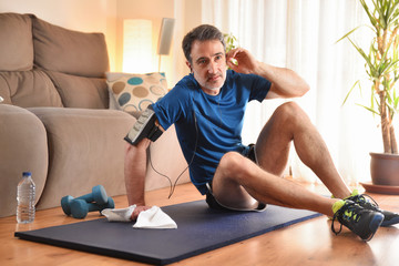 Man resting after doing sports listening to music at home