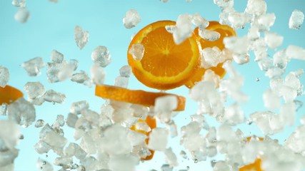 Poster - Super slow motion of falling orange slices with crushed ice on blue background. Filmed on high speed cinema camera, 1000 fps.