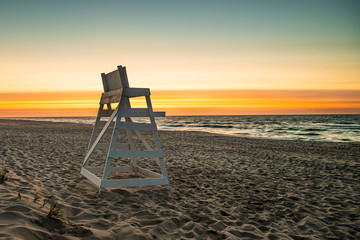 An empty lifeguard stand looks out over the ocean at sunrise at Beach Haven, NJ