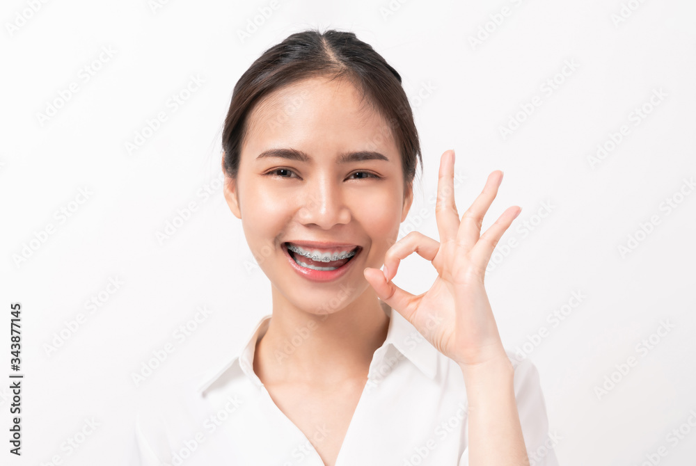 Portrait happily Asian woman shows ok sign and braces smiling witch ...
