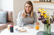 © Drobot Dean - Photo of cheerful young woman eating cereal while having breakfast