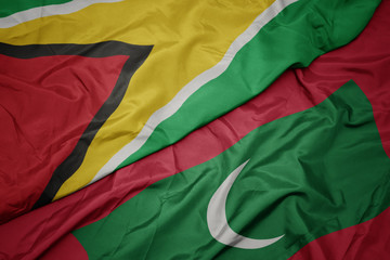 Wall Mural - waving colorful flag of maldives and national flag of guyana.