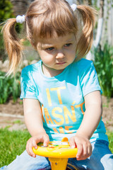 A little girl 2 - 4 years in a flowering garden, sakura. trees blossom.