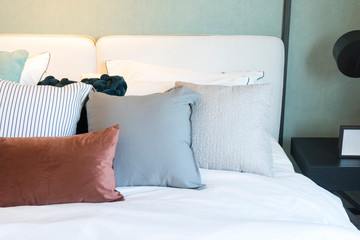 Scandinavian bedroom interior with bed in brown and green colors with table lamp.