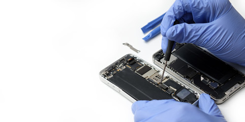 Technician repairing the smartphone's motherboard in the lab with copy space. Cell phone parts and tools for recovery repair and upgrade technology.