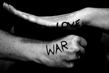 Midsection Of Woman With Love And War Text On Hands