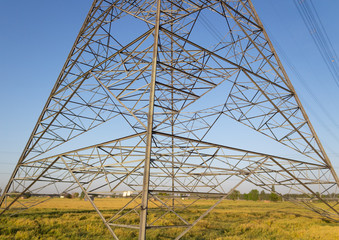 A transmission tower with wheat fields and blue sky in Urban concept.