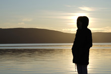 Silhouette Of The Woman Standing And Watching Sunrise.