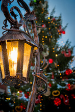 Close-up Of Illuminated Lamp Post Against Christmas Tree At Night
