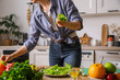 © Cavan Images - Young and beautiful housewife woman cooking in a white kitchen