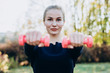 © Cavan Images - Beautiful young girl holding dumbbells stretched out in front of her.