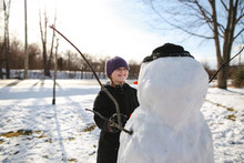 Smiling Girl Making Snowman In Winter