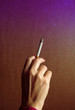 © Cavan Images - A woman's hand, with a lit cigarette.