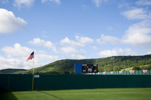 Baseball Outfield Fence And Rolling Hill With Scoreboard And American Flag